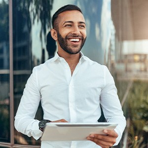 Young male professional smiling outside
