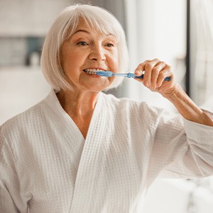Older woman brushing her teeth