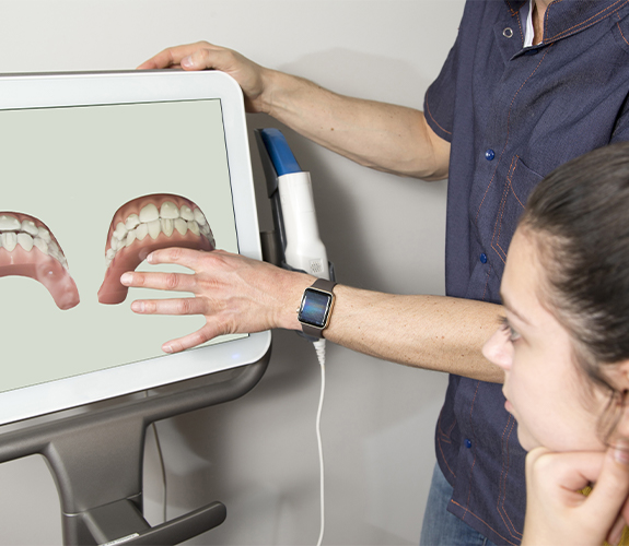 Dentist and dental patient looking at digital Invisalign treatment plan
