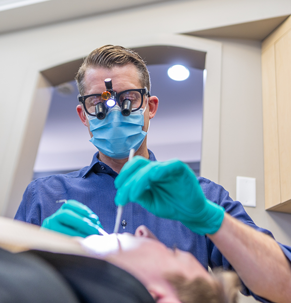 Woman in dental chair smiling at dentist